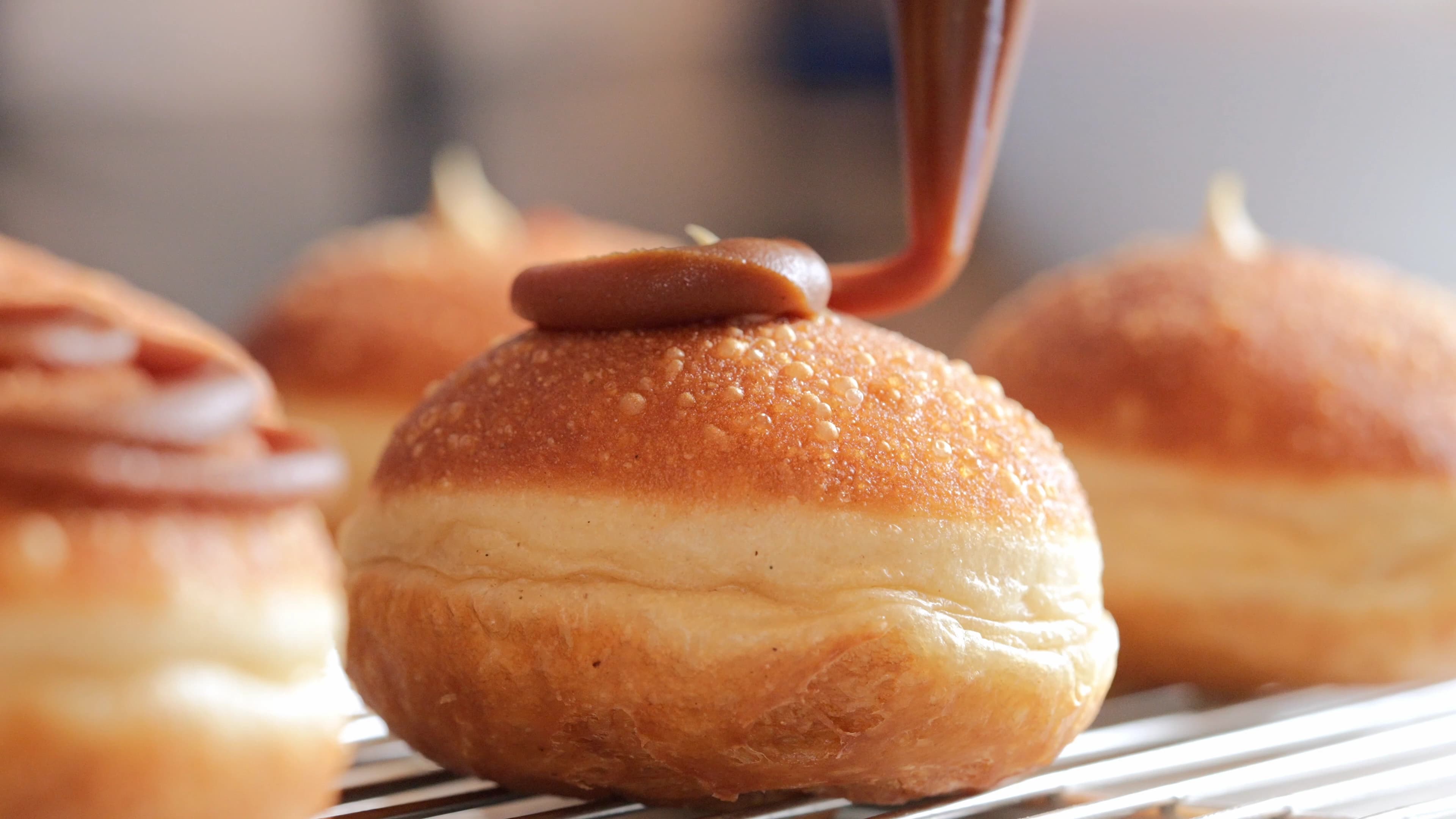 Cream being piped onto a golden pastry